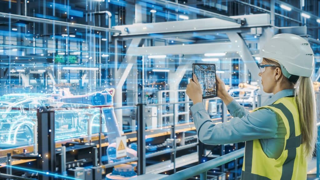 Futuristic Car Factory Digitalization Industry 4.0: Female Automotive Engineer Using Augmented Reality Tablet Computer to Scan Automated Robot Arm Assembly Line Manufacturing Electric Vehicles